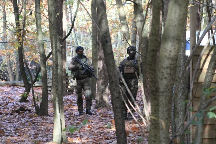 Twee spelers patrouilleren tussen de bomen